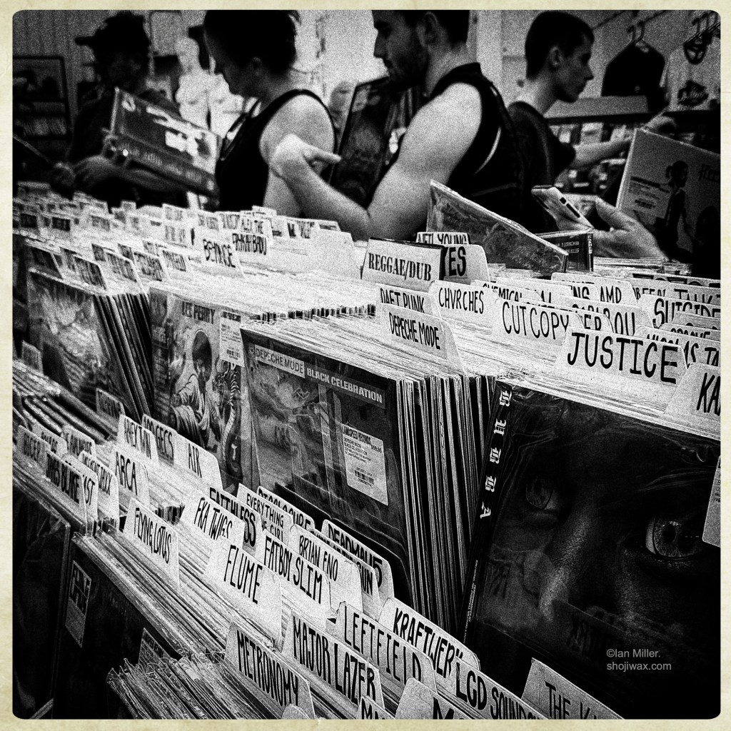 Black and white photo of busy vinyl record store.