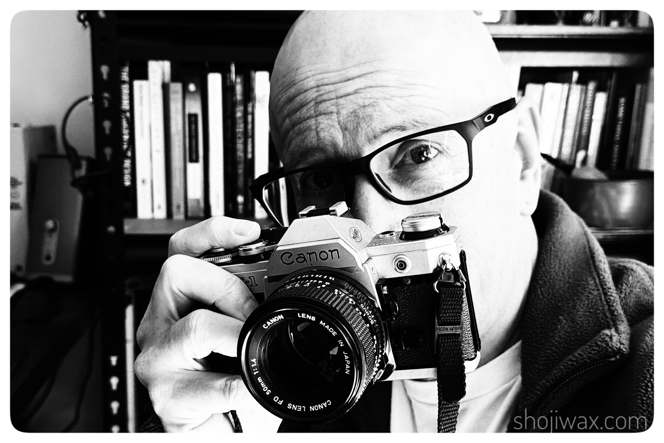 Monochrome selfie of me holding up a Canon film camera.