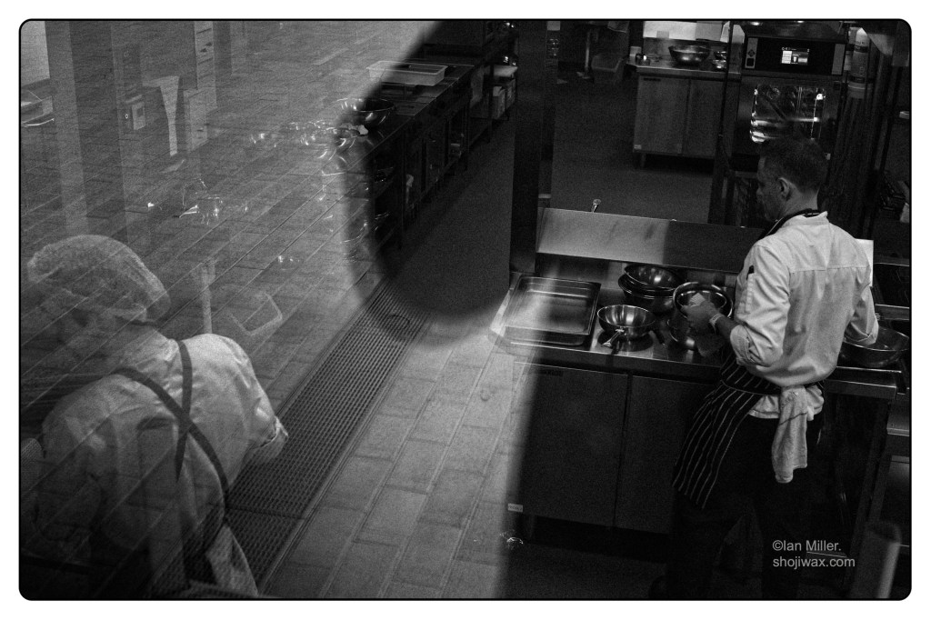 Monochrome photo of industrial kitchen scene.