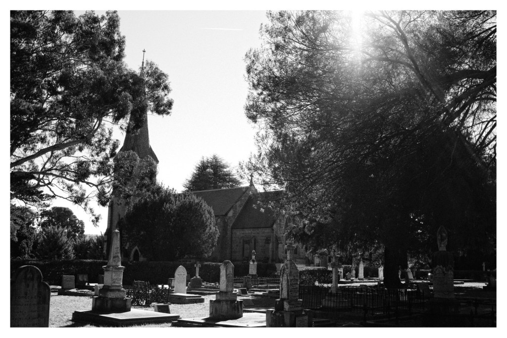 Monochrome photo of church with its graveyard in the foreground.