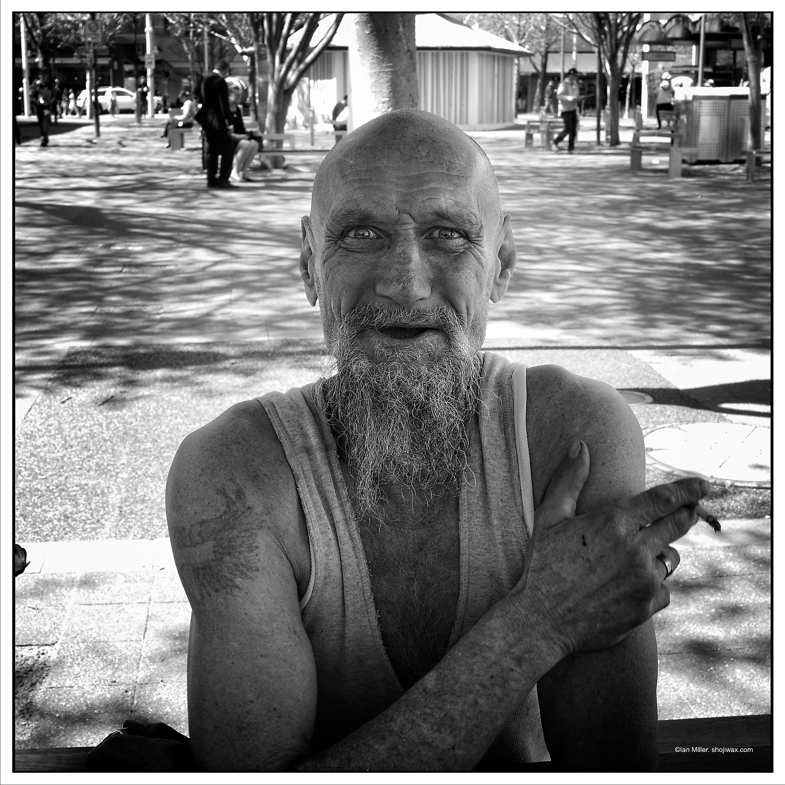Monochrome photo of bearded man wearing a singlet and staring straight at the camera.